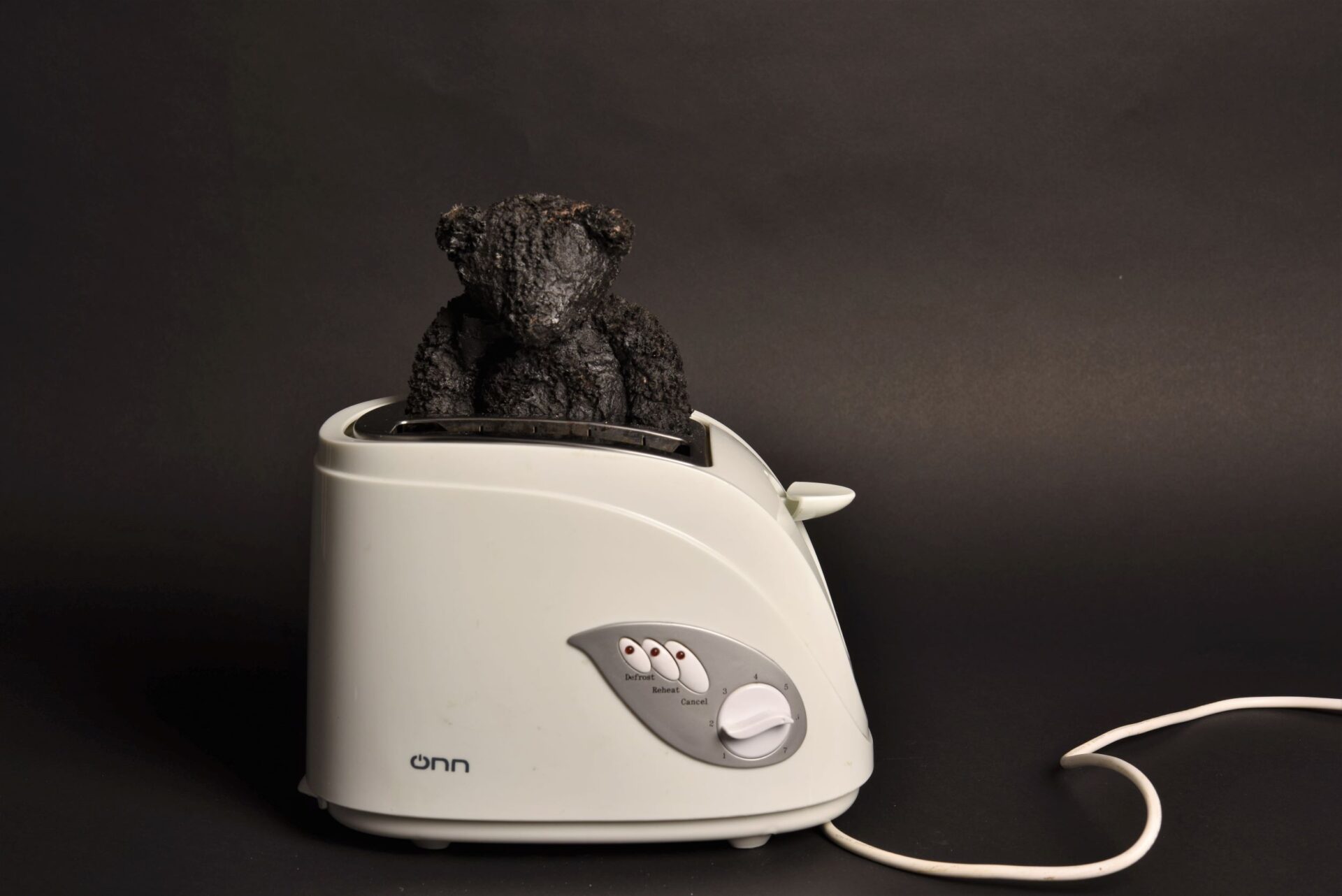 Teddy in a toaster II, toy teddy bear, bitumen paint, ONN toaster, dimensions variable 2021 NFS