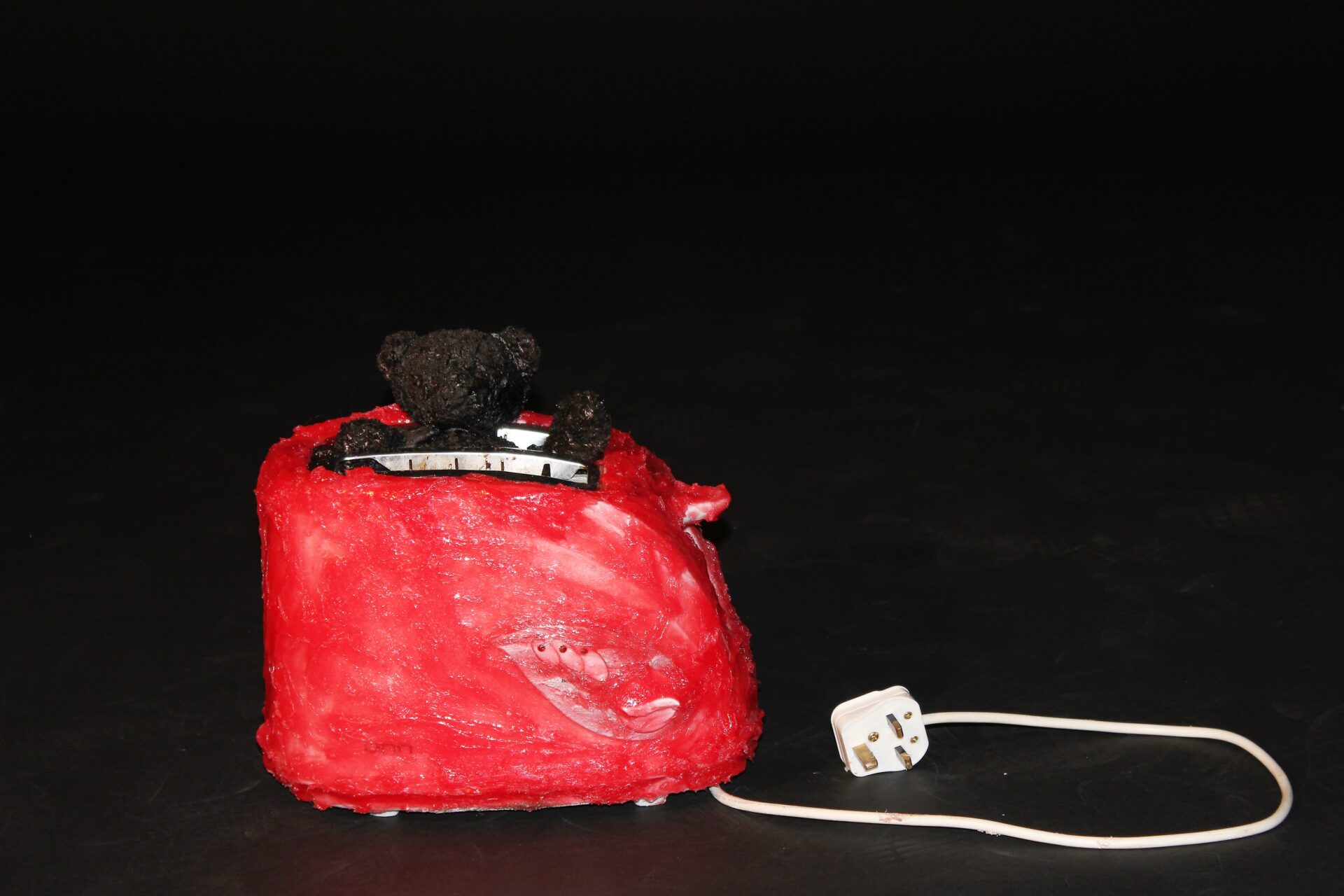 Burnt toast with jam, toaster, silicone, ink, charity shop teddy bear, bituminous paint, dimensions variable 2022 POA